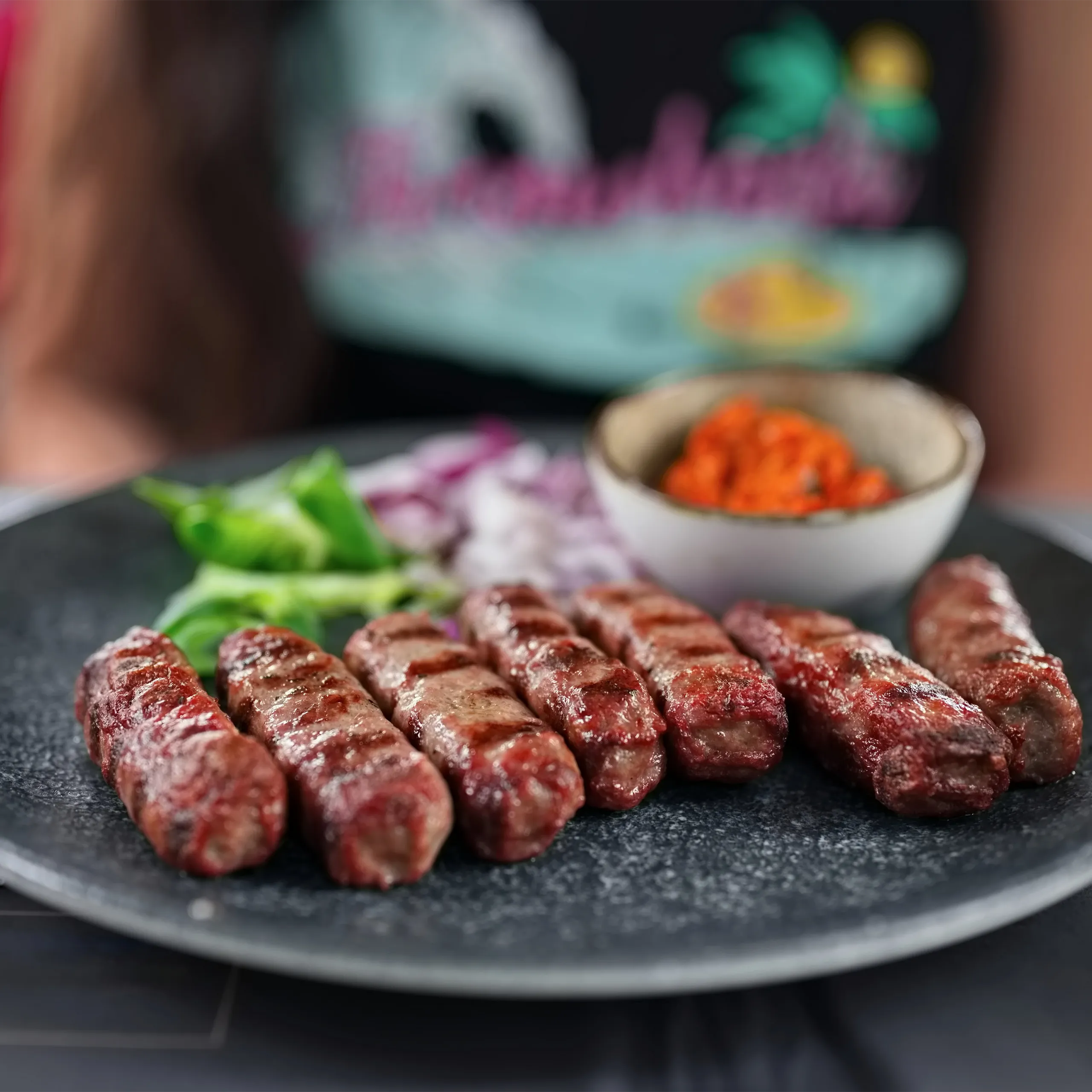 Balkan-Spezialität Ćevapčići mit Ajvar, Zwiebeln und grünem Paprika Balkan-Spezialität Ćevapčići mit Ajvar, Zwiebeln und grünem Paprika